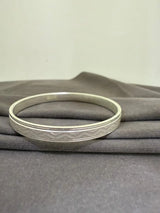 Silver bracelet on a gray fabric background
