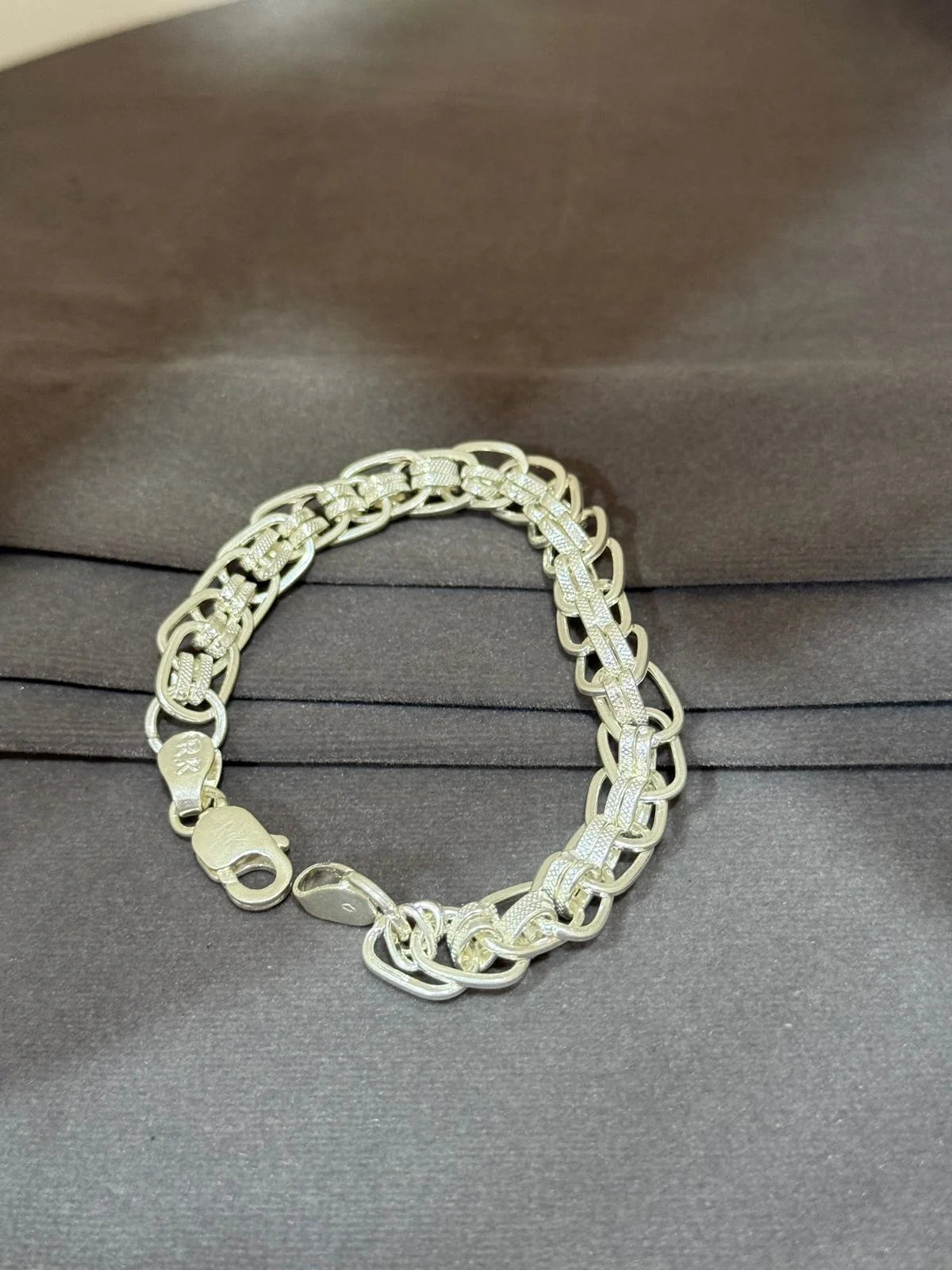 Silver chain bracelet on a gray surface