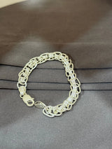 Silver chain bracelet on a gray surface