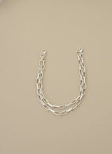 Silver chain necklace on a beige background