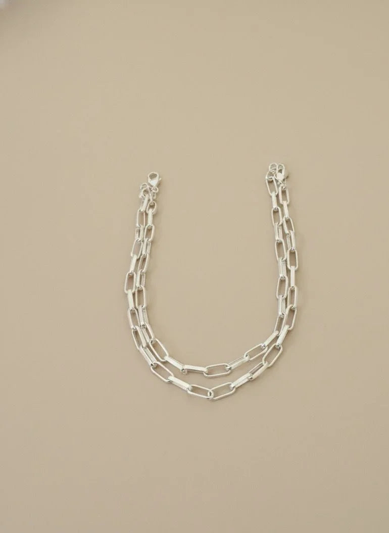 Silver chain necklace on a beige background