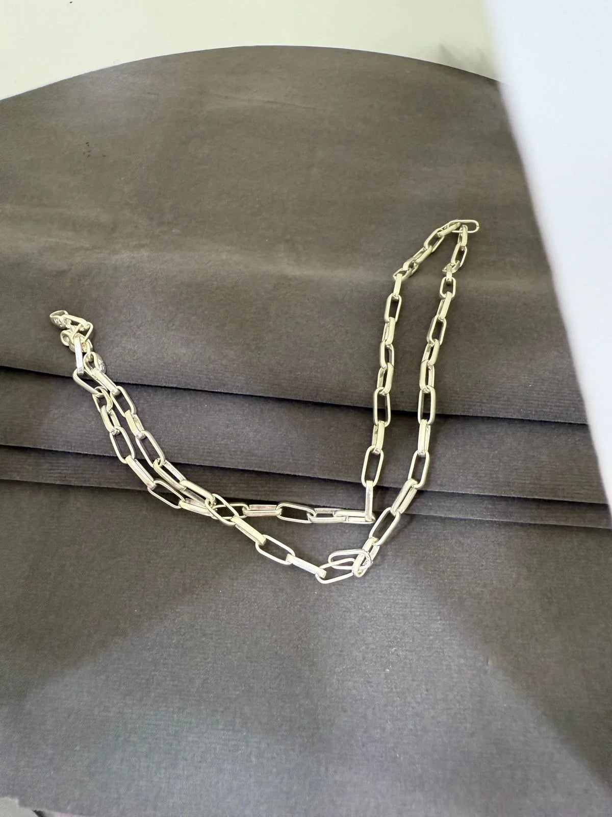 Silver chain necklace on a gray surface