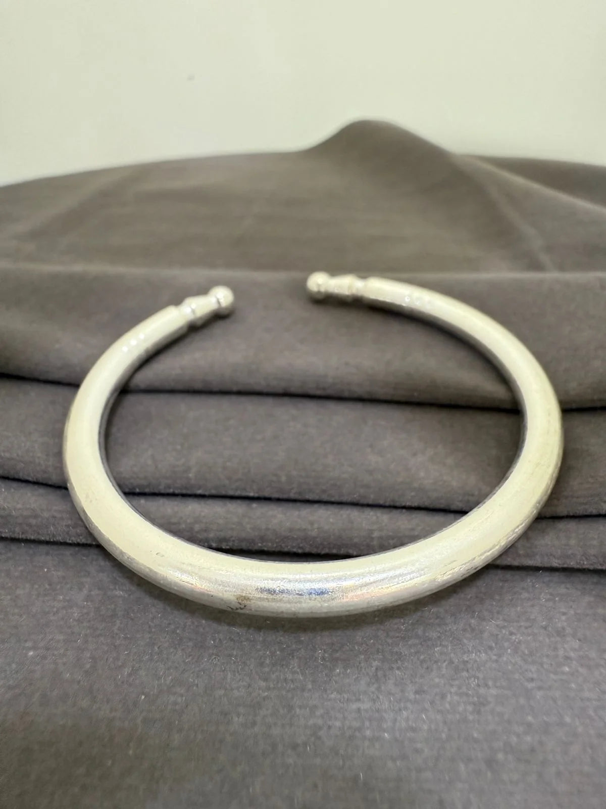 White neckpiece on a gray fabric background