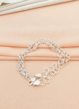 Silver chain bracelet on a beige fabric background
