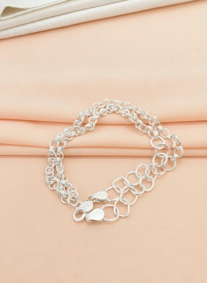 Silver chain bracelet on a beige fabric background