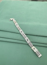 Silver bracelet on a green fabric background