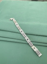 Silver bracelet on a green fabric background