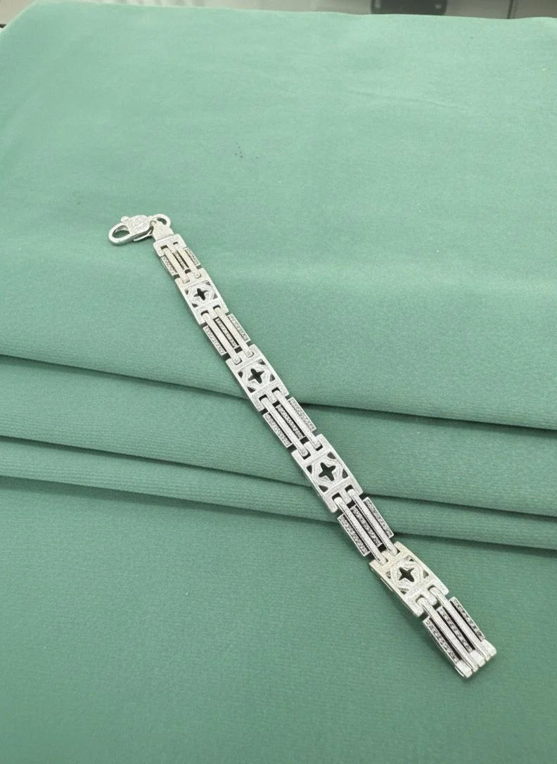 Silver bracelet on a green fabric background