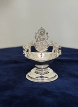 Silver decorative item on a blue fabric background