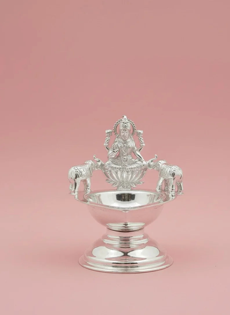 Silver decorative item on a pink background