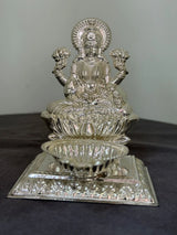 Silver lakshmi on a dark surface with a gray background