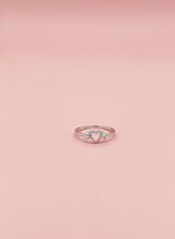 Rose gold ring with a diamond on a pink background