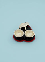 Pair of silver earrings in a red and black case on a light blue background
