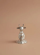 Silver animal figurine on a beige background