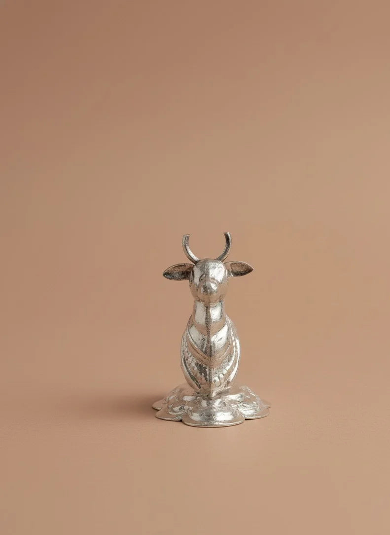 Silver animal figurine on a beige background