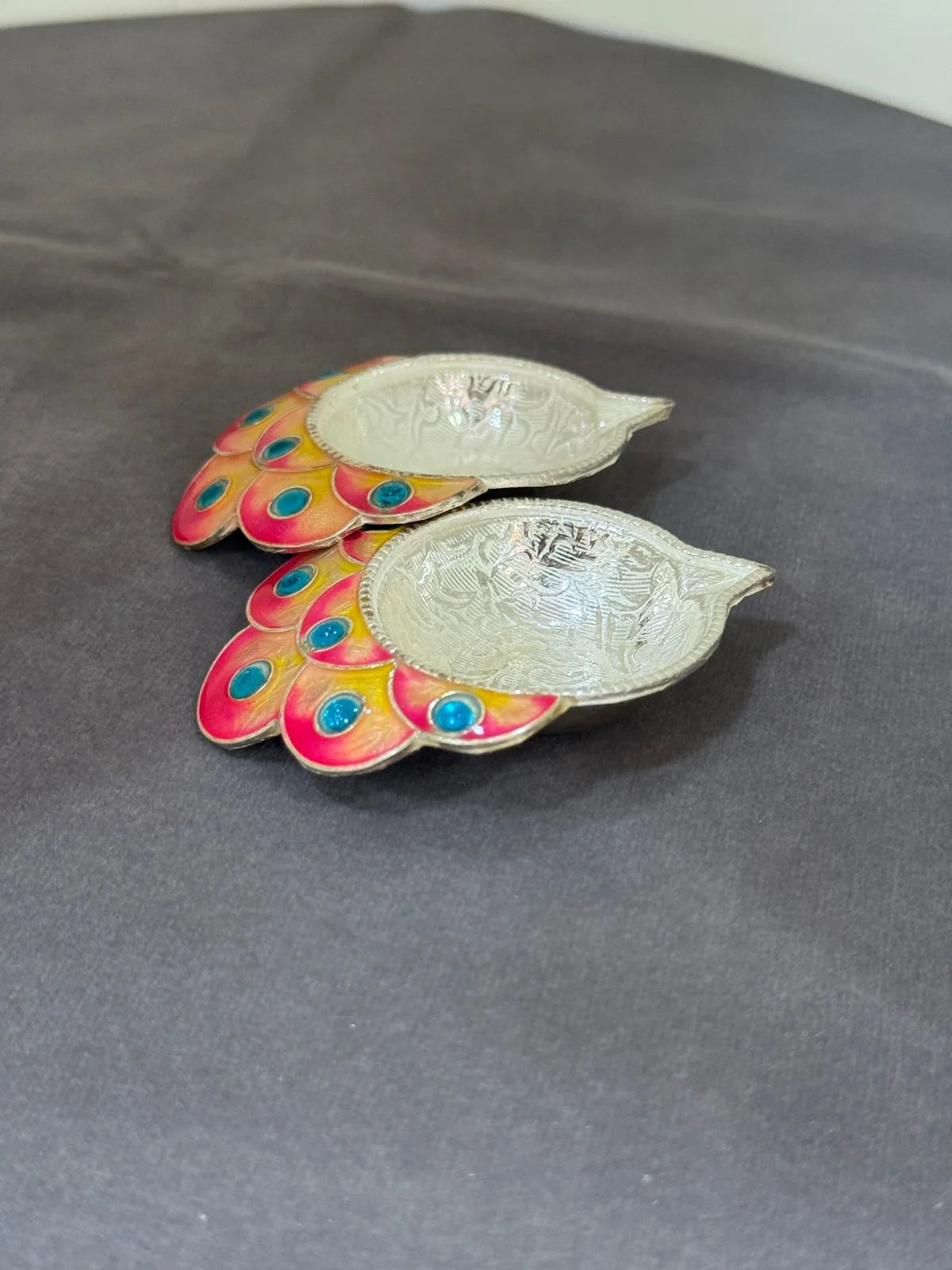 Decorative leaf-shaped objects with colorful patterns on a gray surface