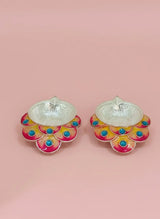 Decorative earrings with colorful floral design on a pink background