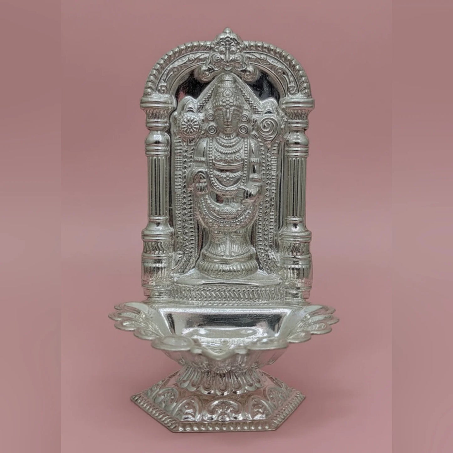 Decorative silver temple structure on a pink background