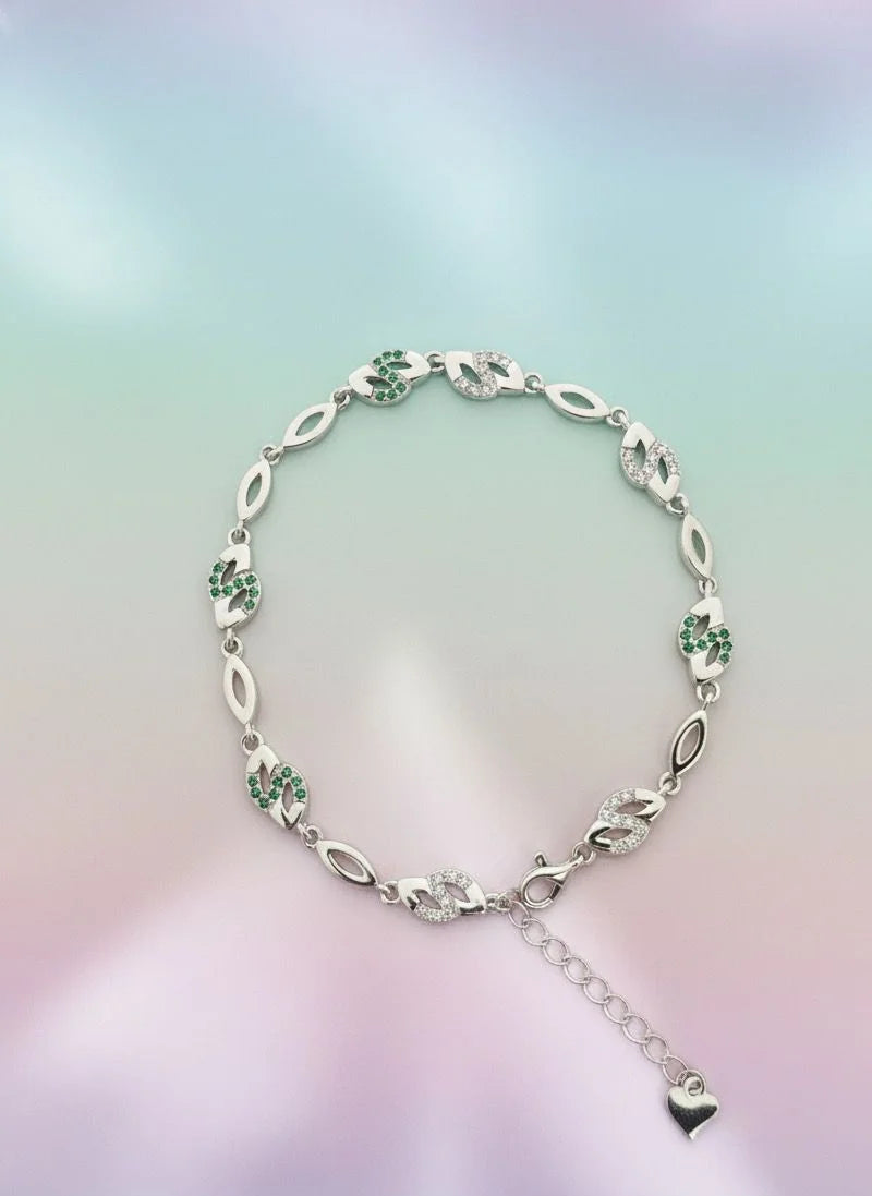 Silver bracelet with green gemstones on a gradient background