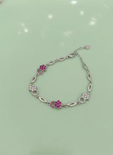 Silver bracelet with pink gemstones on a light green background
