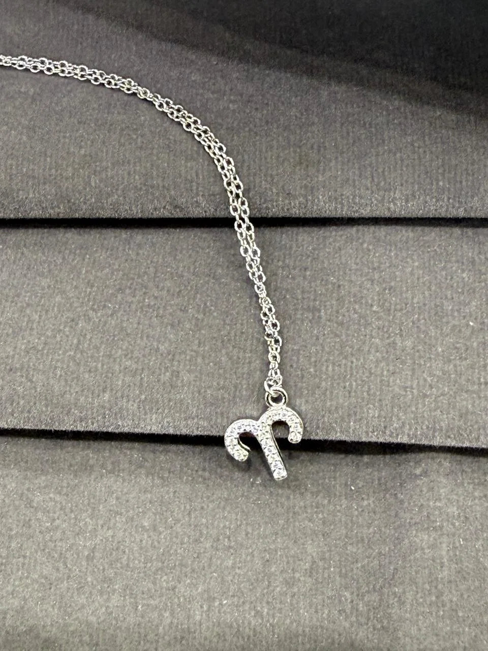 Silver necklace with a small pendant on a gray surface