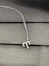 Silver necklace with a small pendant on a gray surface