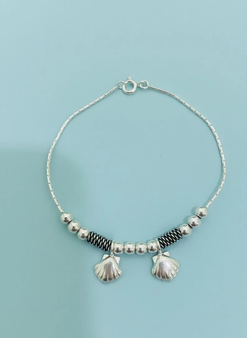 Bracelet with shells on a light blue background