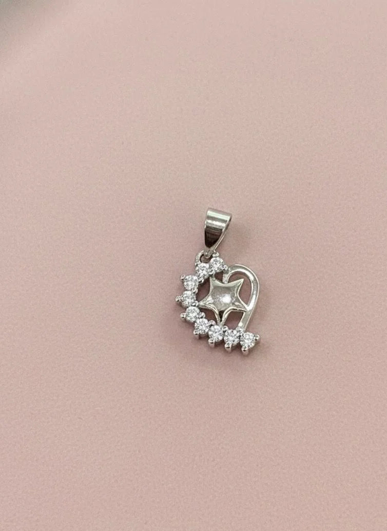 Silver heart-shaped pendant with clear stones on a pink background