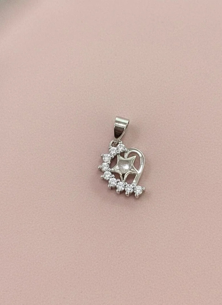 Silver heart-shaped pendant with clear stones on a pink background
