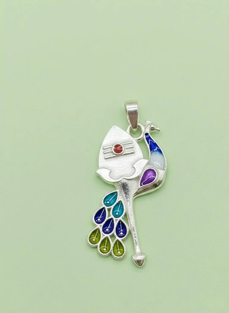 Colorful peacock feather pendant on a light green background