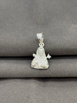 Silver pendant of a seated figure on a gray fabric background