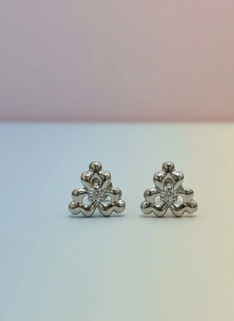 Pair of silver floral earrings on a gradient background