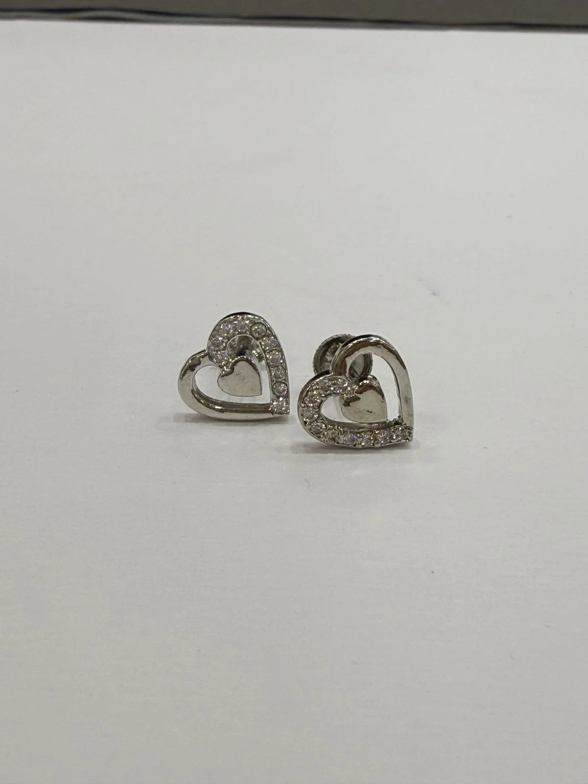 Heart-shaped earrings with clear stones on a white background