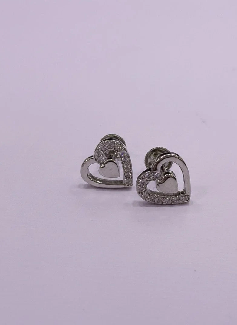 Heart-shaped earrings with embedded stones on a light purple background