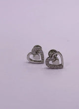 Heart-shaped earrings with embedded stones on a light purple background