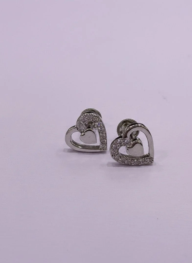 Heart-shaped earrings with embedded stones on a light purple background