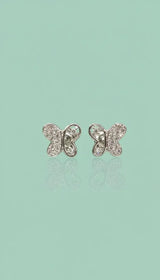 Butterfly-shaped earrings on a light green background