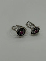 Pair of silver toe rings with purple stones on a light gray background