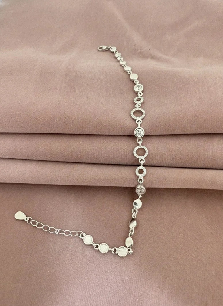 Silver bracelet on a pink satin background