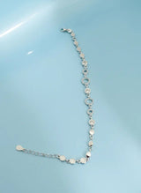 Silver bracelet on a light blue background