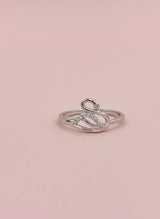 Silver ring with small diamonds on a pink background
