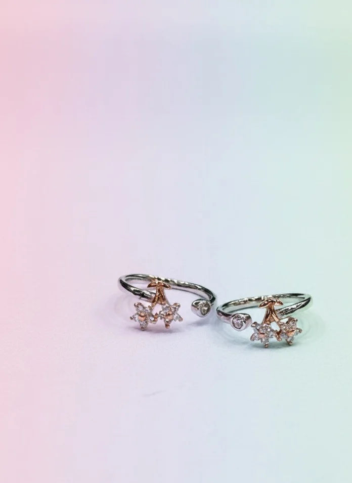 Pair of rose gold toe rings with small gemstones on a gradient background