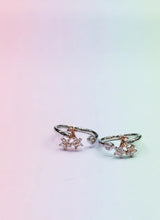 Pair of rose gold toe rings with small gemstones on a gradient background