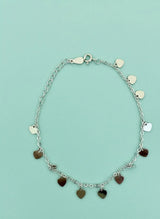 Silver bracelet with heart-shaped charms on a light blue background